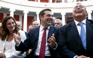 Ζάππειο Μέγαρο, Αθήνα, 22 Ιουνίου 2018. Ο πρωθυπουργός Αλέξης Τσίπρας (πρώτη φορά δημοσίως με γραβάτα) και ο κυβερνητικός συνεταίρος του, υπουργός Άμυνας (και πρόεδρος των ΑΝΕΛ) Πάνος Καμμένος, πανηγυρίζουν για την επιμήκυνση του χρέους, στην οποία κατά το παρελθόν είχαν αντιταχτεί. Αριστερά, η πρωθυπουργική σύζυγος Περιστέρα Μπαζιάνα. Hτριάδα πλαισιώνεται από την περιφερειάρχη Αττικής Ρένα Δούρου (πριν τύχει «η στραβή στη βάρδια της») και από τον αντιπρόεδρο της κυβέρνησης και υπουργό Οικονομίας και Ανάπτυξης, Γιάννη Δραγασάκη, πριν του αφαιρεθεί η αρμοδιότητα για τις τράπεζες.